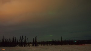 Light pollution bouncing off a cloudy sky with minimal aurora.